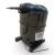 Left-side view of the used Copeland CF04K6E-TF5 1 HP compressor, showing the embossed Copeland "C" logo terminal box cover, a brass service valve fitting extending from the top, and a bent copper return line at the base.