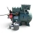 Side view of the used Carlyle 06DM8086GC3250 3 HP semi-hermetic compressor (3 phase, 208-230 volt), showing the teal cylinder head with rust patches, the bolted terminal box cover on top, an oil sight glass on the front, and a small copper access valve with braided line on the right.