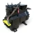 Straight-on front view of the used Copeland 2DA3-R89KE-TFD 7.5 HP compressor, 3 phase 460 volt, with a gray-black two-tone housing, the blue Copeland Discus data plate, and a yellow tag hanging near the base.