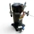Front view of the used Copeland ZF18KVE-TF5 6 HP compressor, showing a yellow "CAUTION - Verify Rotation Prior to..." warning tag, a red inventory tag, and the blue-and-white Emerson OMB oil-level control system mounted at the base.