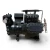 Angled front-left view of the used Copeland 6DL3-F93KE-TSK 27 HP compressor, 3 phase Dual Voltage, black finish, showing a foil-capped left valve fitting, a foil-capped service valve with a rust-toned ball valve on the right, and the finned oil cooler on top.