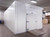 White used walk-in commercial freezer with closed hinged door and ramp
