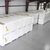 Stacked pallets of insulated cold storage panels wrapped in plastic, showing construction