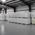 Stacked pallets of insulated cold storage panels wrapped in plastic, showing construction