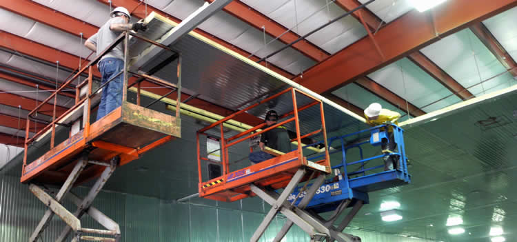 Barr crews dismantling a large walk-in cooler inside an industrial building