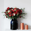 red roses in a dark vase for valentine and romance and anniversary events.