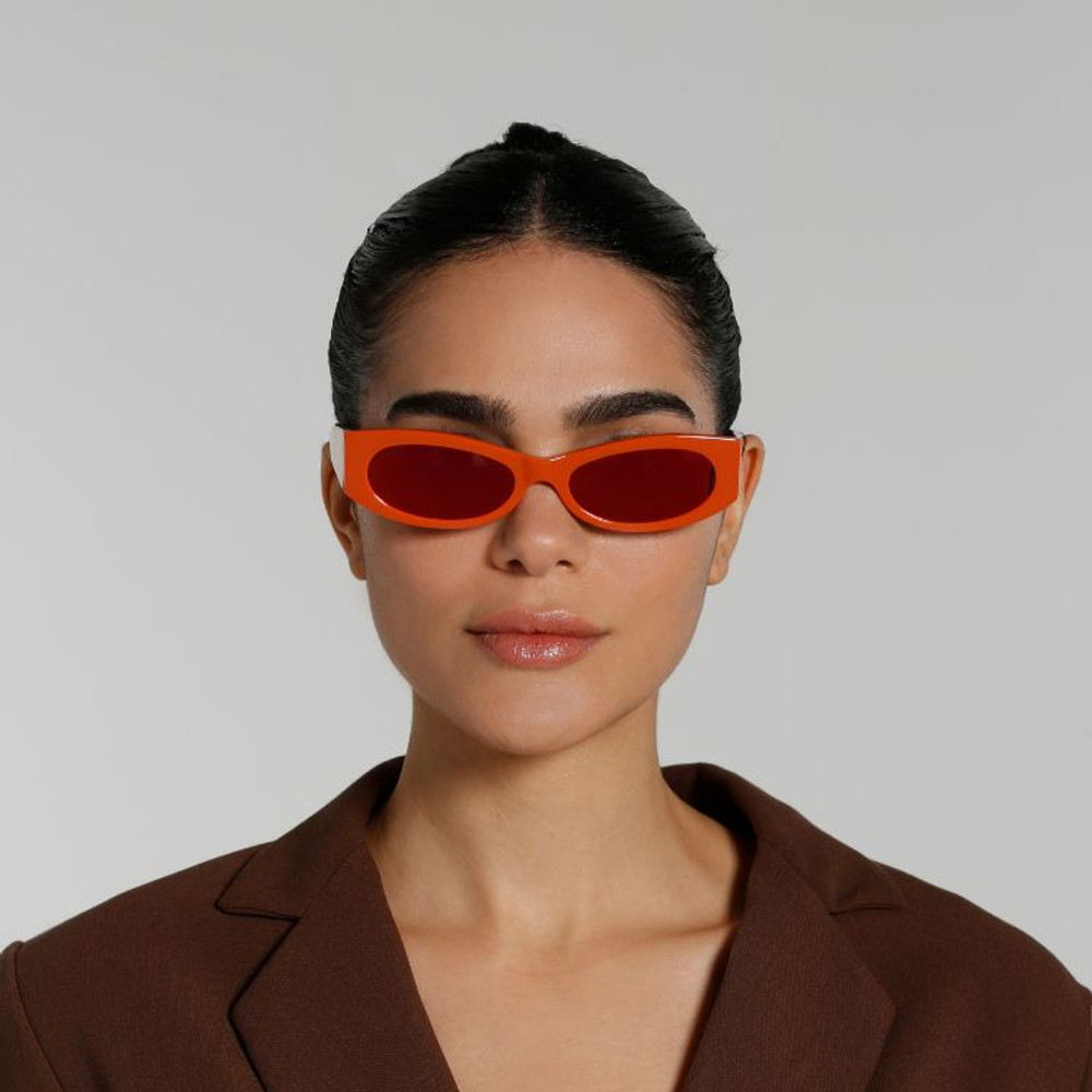 Front view of model wearing sunglasses | Cat-like sunglasses with orange mirror lenses and orange frames | Acetate | Ciara | Women's sunglasses | Karen Wazen Eyewear