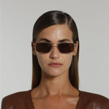 Front view of model wearing sunglasses | Rectangle sunglasses with brown lenses and brown frames | Metal | Devon | Women's, men's, and unisex sunglasses | Karen Wazen Eyewear
