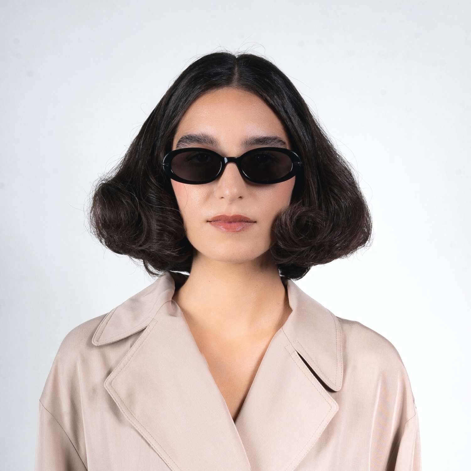 Front view of model wearing sunglasses | Oval sunglasses with black lenses and black frames | Metal & Acetate | Olivia | Women's sunglasses | Karen Wazen Eyewear