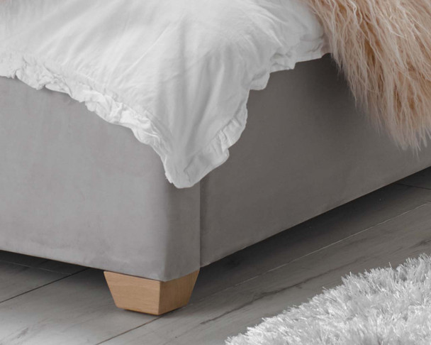 detail of bed foot with grey upholstry