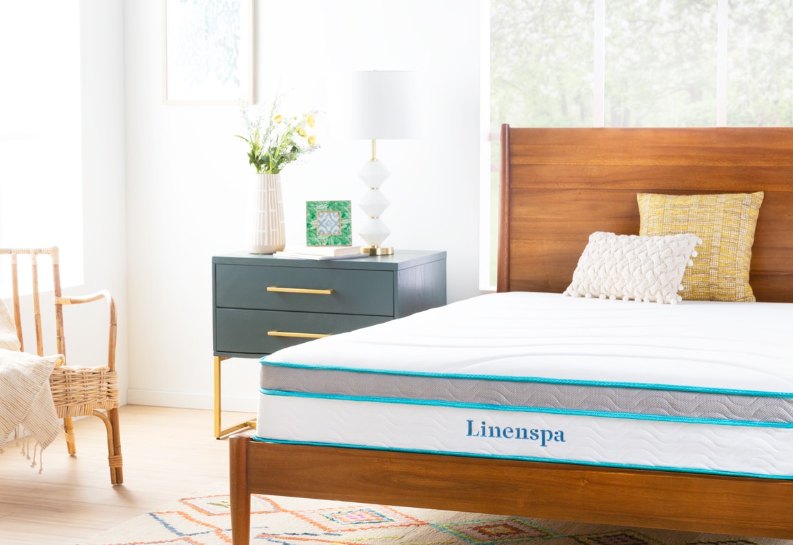 Linenspa mattress on a wooden base in a room with a dresser and chair