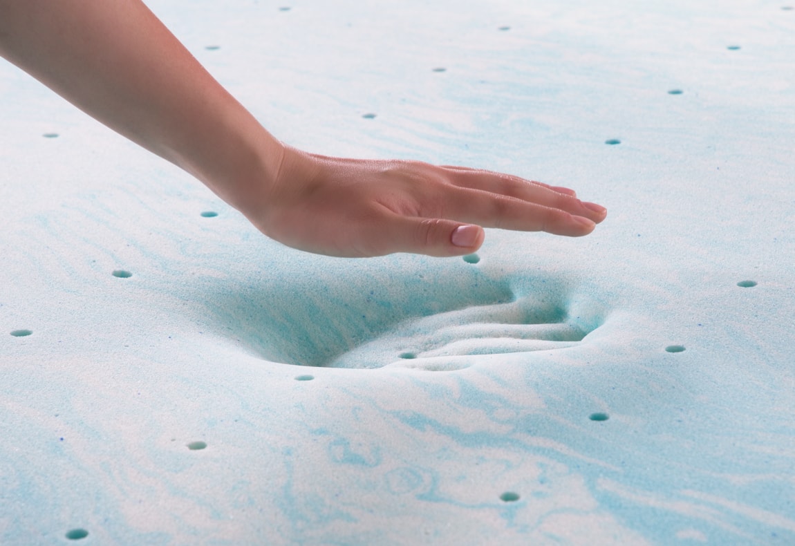 Hand pressing down on a 2" Gel Swirl Memory Foam Mattress Topper