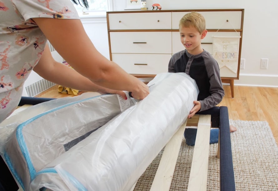 Mom and child unboxing their Linenspa 6" innerspring mattress