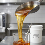 bartender-pouring-organic-agave-syrup-into-large-batch-cocktail-dispenser