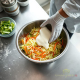 Folding extra heavy duty mayonnaise into coleslaw in a commercial kitchen (AI-generated lifestyle scene)