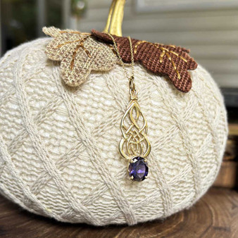 Pendant in 14kt yellow gold with intricate, curving knotwork and a 3.06ct Iolite.