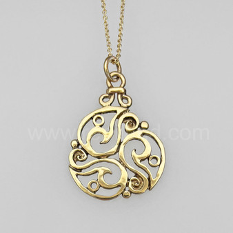 The Inishglora Triskele Pendant features an intricate, openwork circular design based on a traditional triskele motif. Pictured in yellow gold.