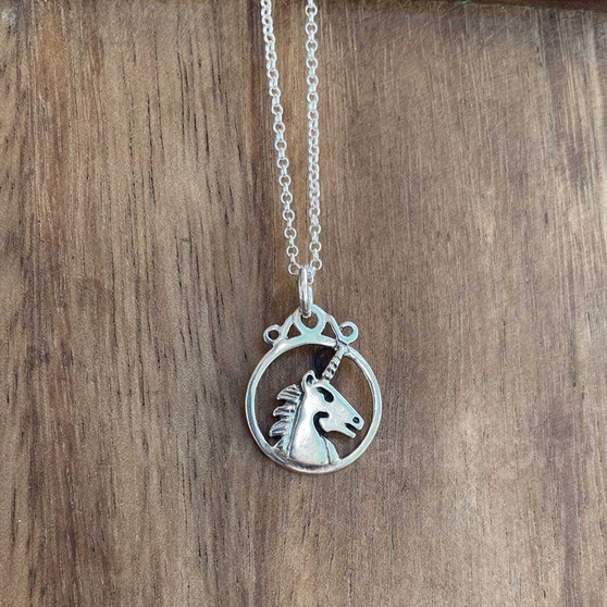 The Dìleab Pendant has a unicorn head in profile within a circle frame.