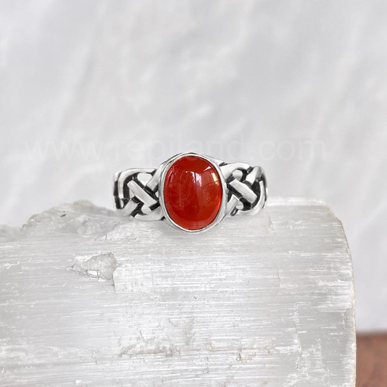 The Elidir Gem Ring features intricate, pierced knotwork with an 8x10mm gemstone. Pictured with Cornelian.