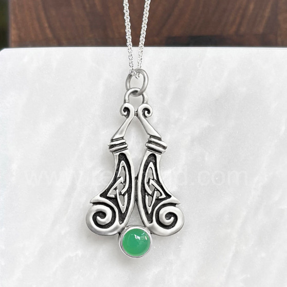 The Boreray Gem Pendant features curving pieces with elongated trinity knots and spiraled ends above an 8mm gemstone. Shown with Chrysoprase.
