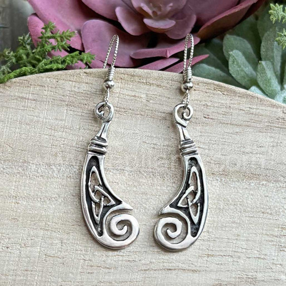 The Boreray Knot earrings have a curved, mirrored design with trinity knots and curled ends. 