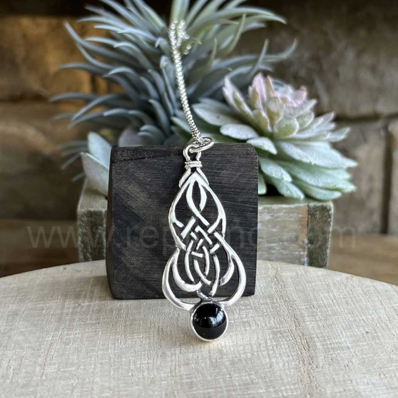 The Blàth Gem Pendant has intricate knotwork and an 8mm gemstone. Shown with Onyx.