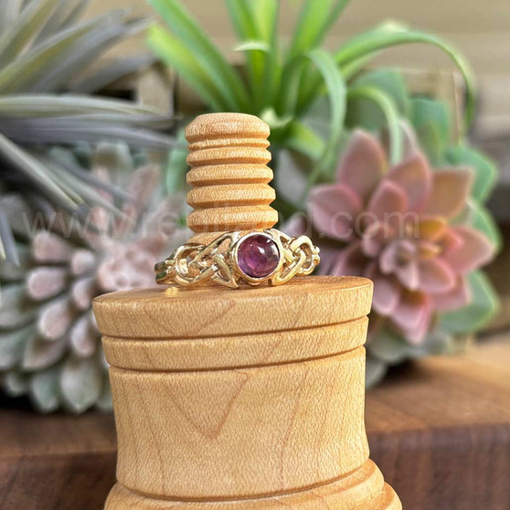The Ribean Gem Ring has a 6mm gemstone, triangular pierced knotwork and a grooved back. Shown in yellow gold with Amethyst.
