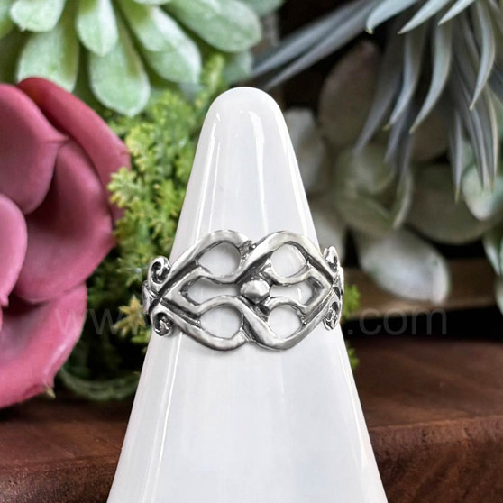 The Fadó Knot Ring is formed from two overlapping heart shapes with curled ends and large bead accent at center.