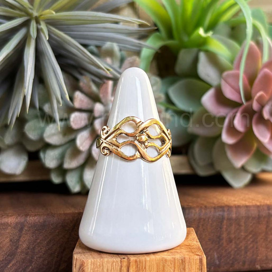 The Fadó Knot Ring is formed from two overlapping heart shapes with curled ends and large bead accent at center. Shown in rose gold.