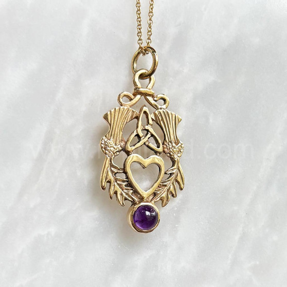 The Lannier Gem Pendant features thistles, leaves, a trinity knot, a heart and a 6mm gem. Pictured in yellow gold with Amethyst.