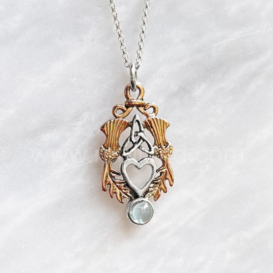 The Lannier Gem Pendant features thistles, leaves, a trinity knot, a heart and a 6mm gem. Pictured in rose gold, sterling and Blue Topaz.