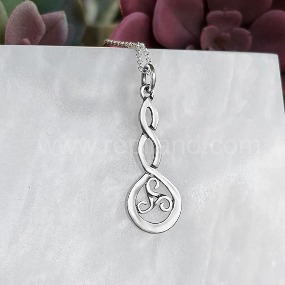 The Grian Triskele Pendant features a graceful twist drop with a triskele.