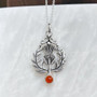 The Lyall Gem Pendant has a central thistle flower, curving side leaves and a 6mm gem at the bottom. Shown with Cornelian.