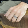 The Elidir Knot Ring features intricate pierced knotwork. Shown on size 12 finger.