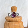 The Elidir Gem Ring features intricate, pierced knotwork with an 8x10mm gemstone. Pictured with Amethyst.