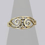 The Theia Ring features an almond shape frame with pierced silver swirls and bead accents. Shown in yellow gold.