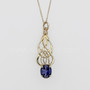 Pendant in 14kt yellow gold with intricate, curving knotwork and a 3.06ct Iolite.