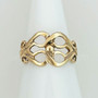 The Fadó Knot Ring is formed from two overlapping heart shapes with curled ends and large bead accent at center. Shown in yellow gold.
