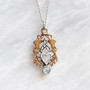 The Lannier Gem Pendant features thistles, leaves, a trinity knot, a heart and a 6mm gem. Pictured in rose gold, sterling and Blue Topaz.