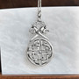 The Vorthr Knot Pendant has stylized serpent dragon heads above a large circular shield knot.