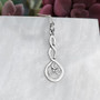 The Grian Triskele Pendant features a graceful twist drop with a triskele.