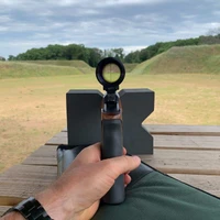 Shooter positioning rifle on closed-cell foam rest placed on wooden shooting table, demonstrating lightweight bench rest setup for improved accuracy.