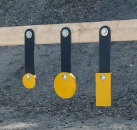 Steel shooting target installed on wooden 2x4 frame, showing rubber strap mount absorbing impact and creating reactive movement during live fire training.