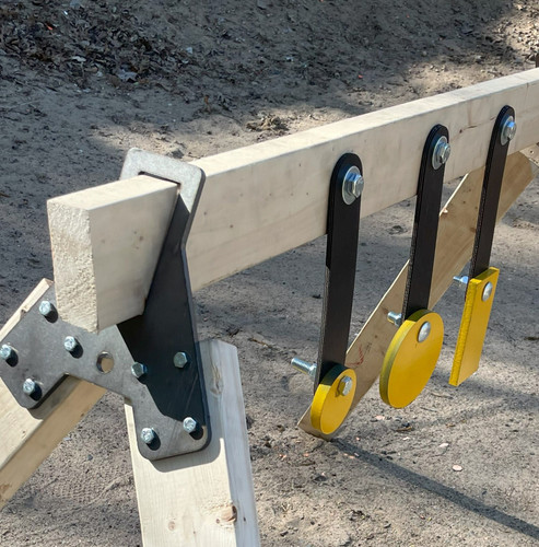 Backyard range setup with steel target mounted to 2x4 frame, demonstrating DIY installation using wood stand and rubber strap suspension system in open field environment.