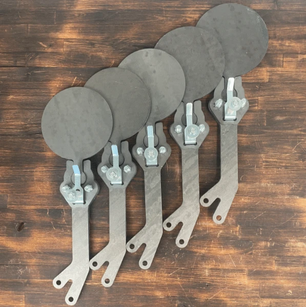 Close-up view of CNC laser-cut AR500 steel target plate mounted on spring-loaded Texas Star arm with adjustable tension bracket hardware.