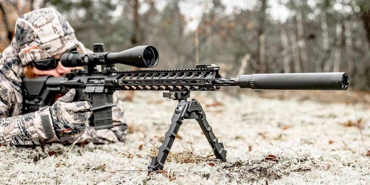 person aiming long-range rifle on bipod