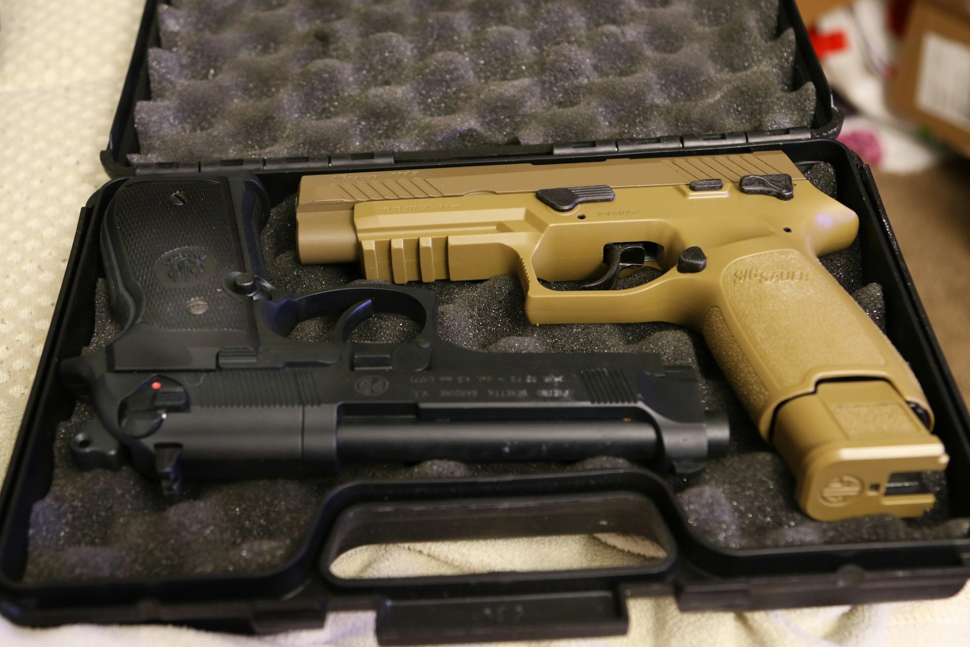 A Beretta 92 and a SIG M18 in a case 