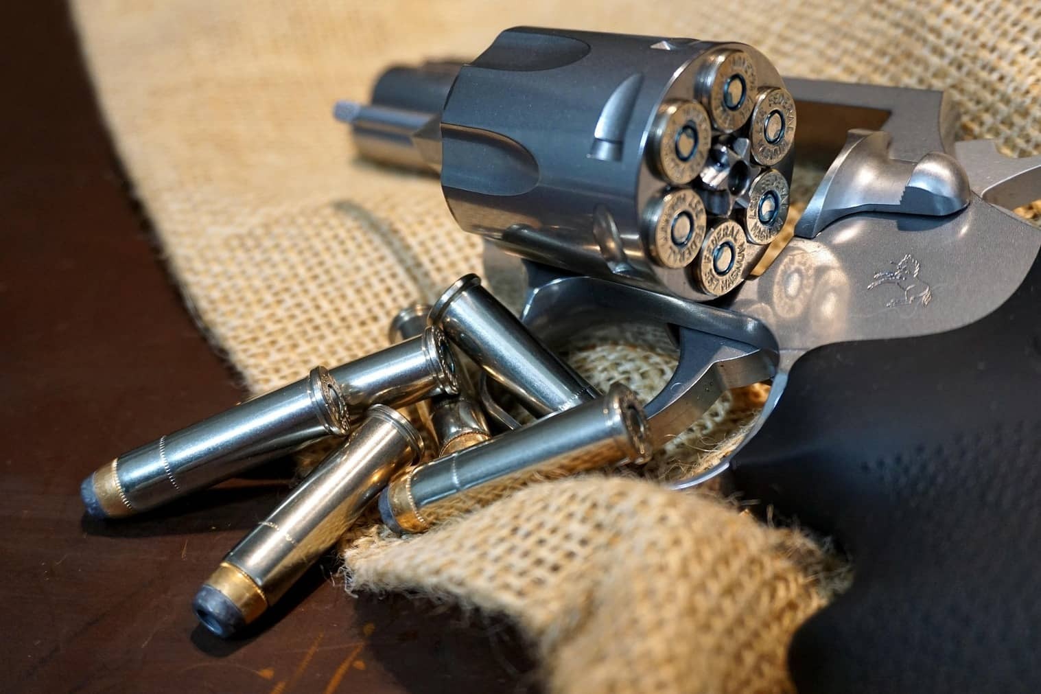 Loaded revolver with open cylinder and spare cartridges on table