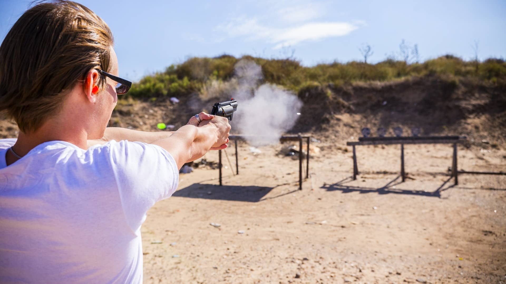 Picture of a man firing a pistol outside