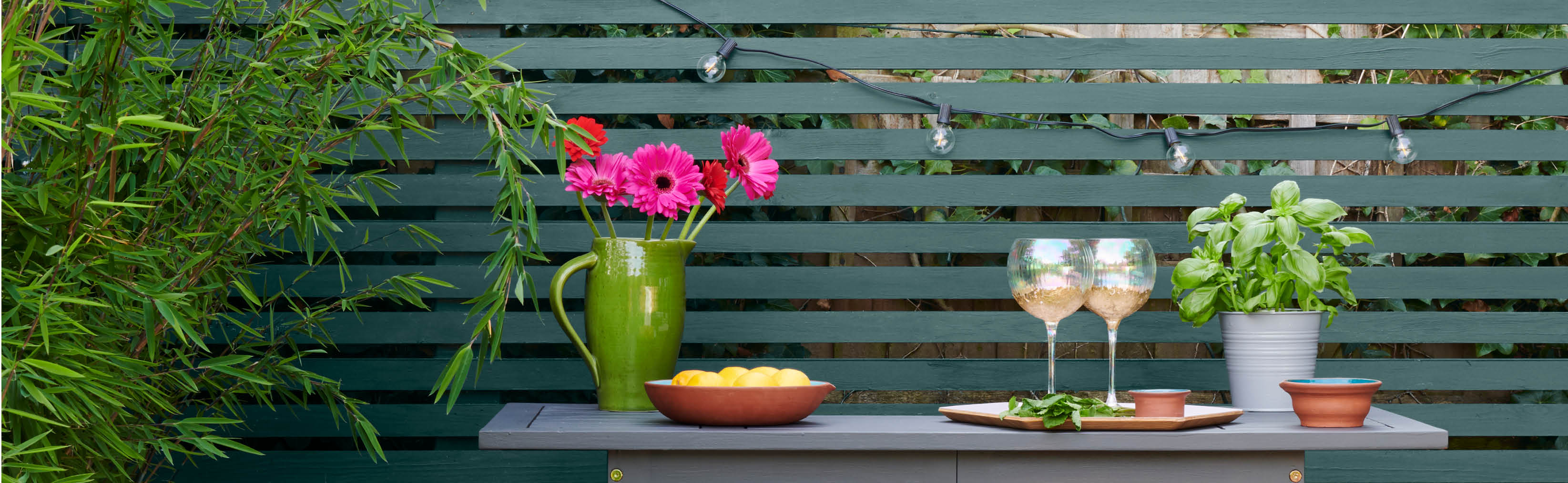 White panels painted in Rust-Oleum Moonstone, behind a mid-green planter painted in Rust-Oleum Serenity